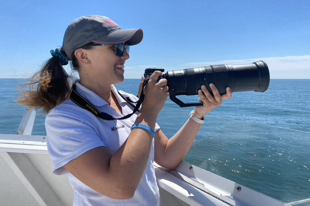 Melissa Laurino, November 2023 eBirder of the Month holds camera while aboard a boat.